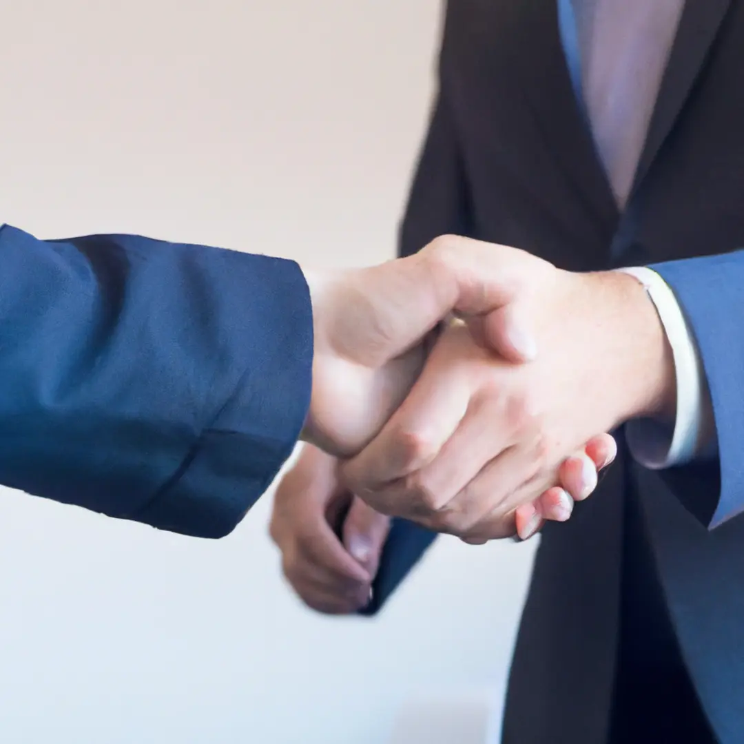 Alternative image alt-text: Handshake between two business people, representing successful negotiations in due diligence term sheets and agreements.