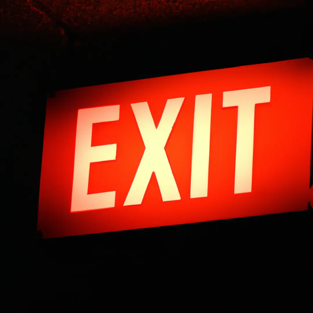 Exit sign on a dark background, symbolizing the need to end a business partnership.