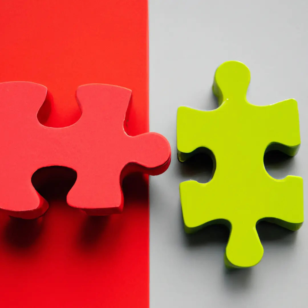 Picture: Two puzzle pieces with different colors trying to fit together Alternative image alt-text: Clashing puzzle pieces representing differences in cultures and working styles in business partnerships